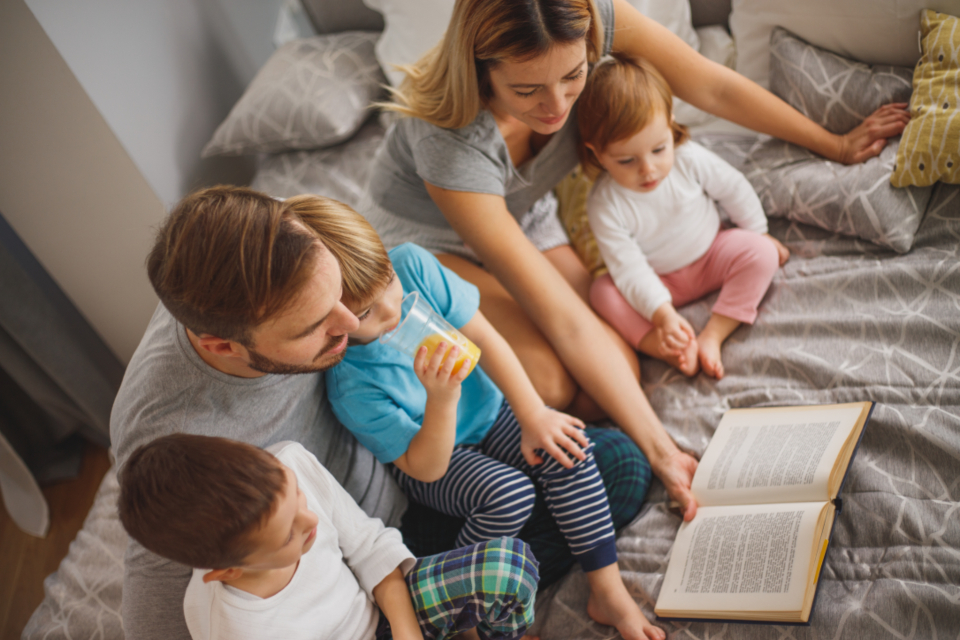 A family gathered in bed for a bedtime story